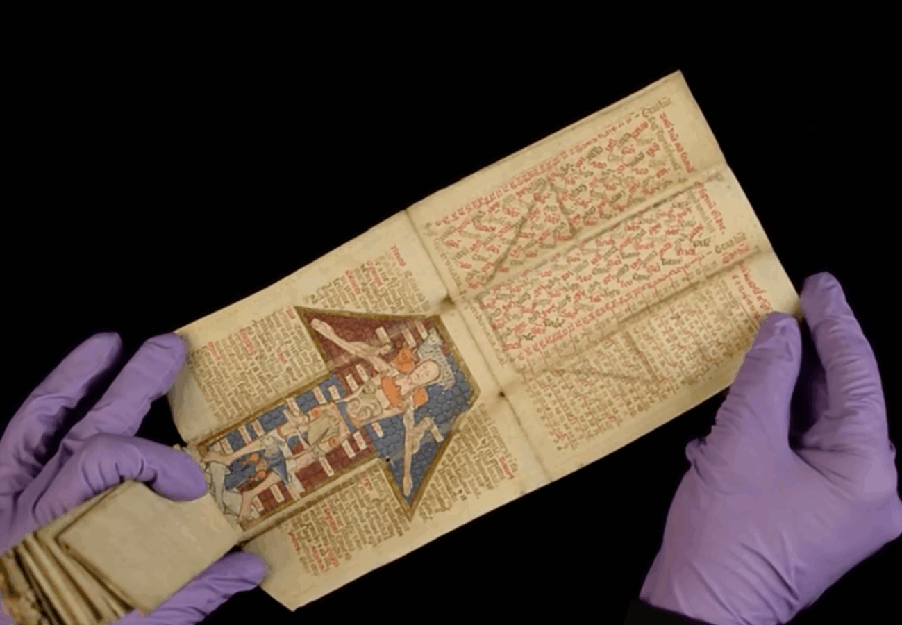 Gloved hands unfold a 15th-century Latin almanac featuring colorful medieval illustrations and handwritten text.